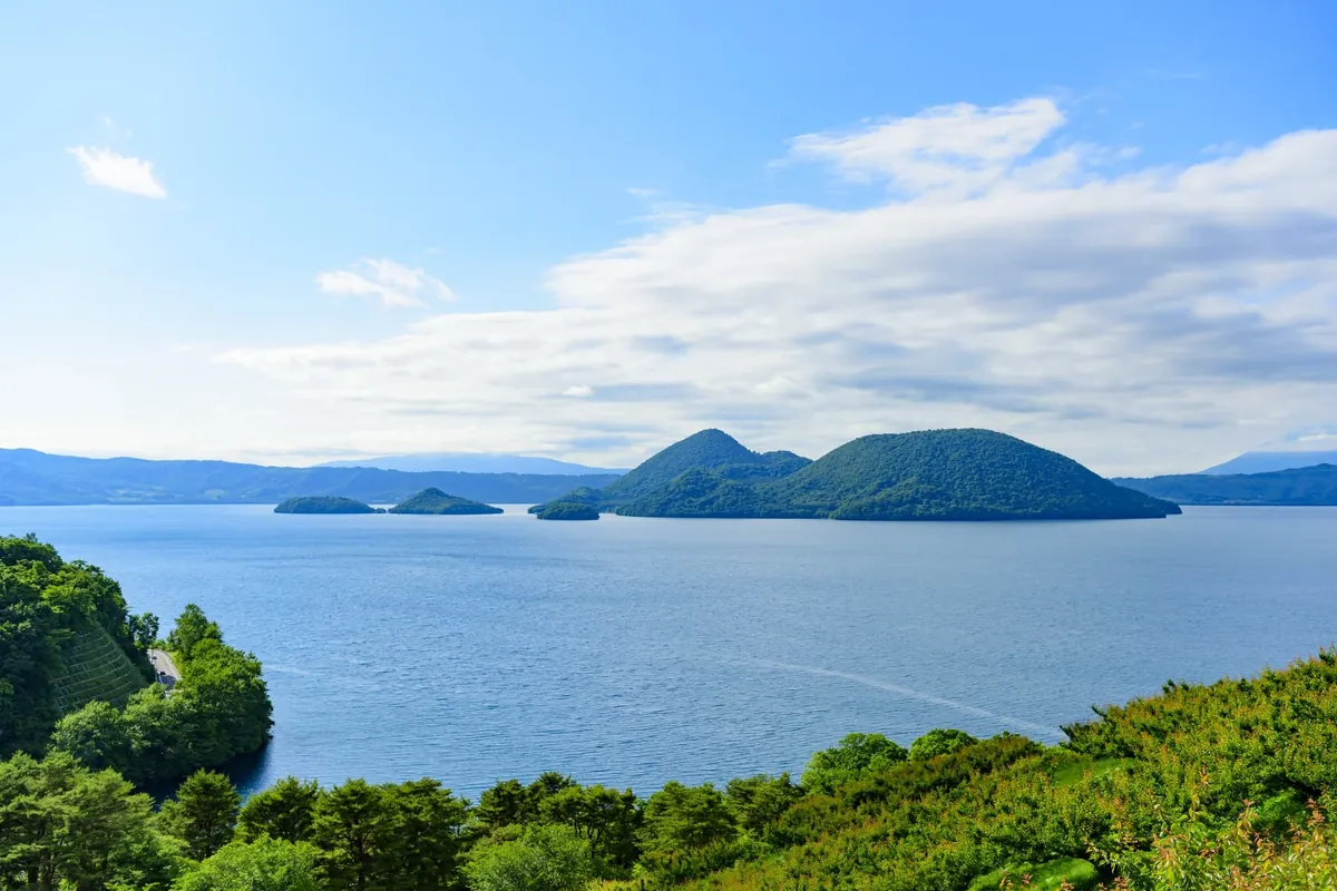 Crystal clear waters of Lake Toya with Mount Usu visible on the southern rim